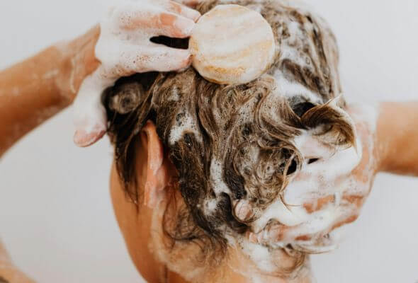 lady taking shower using shower filter for dandruff