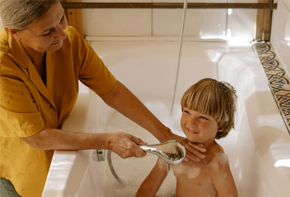 mother showering her kid with adjustable shower head