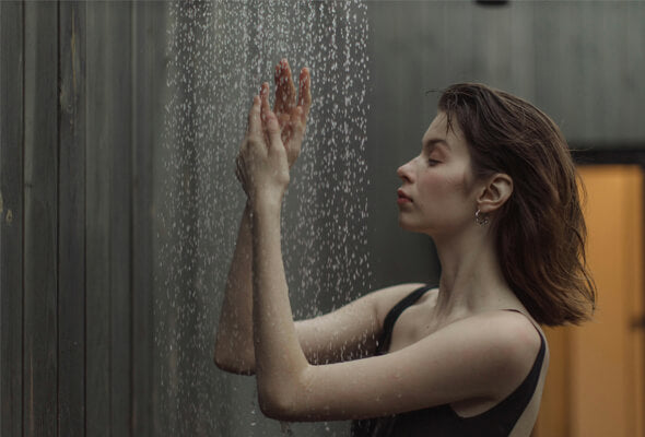 pretty woman taking shower with filter for shower head