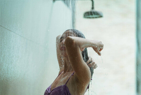 young lady using high flow showerhead