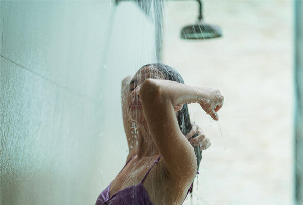 young woman using powerful showerhead