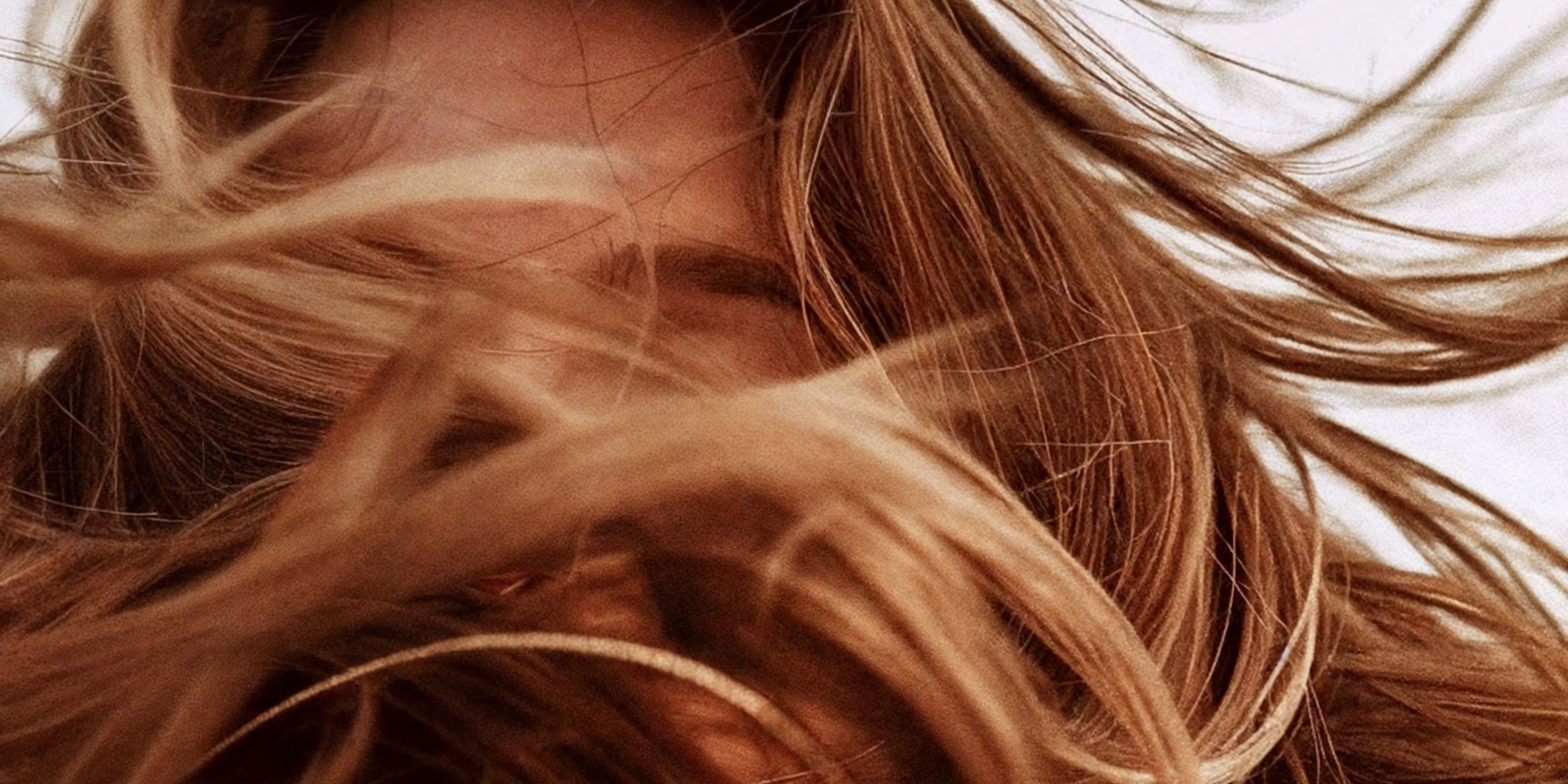 Close up of ladies long hair blowing across the image and obscuring her face 