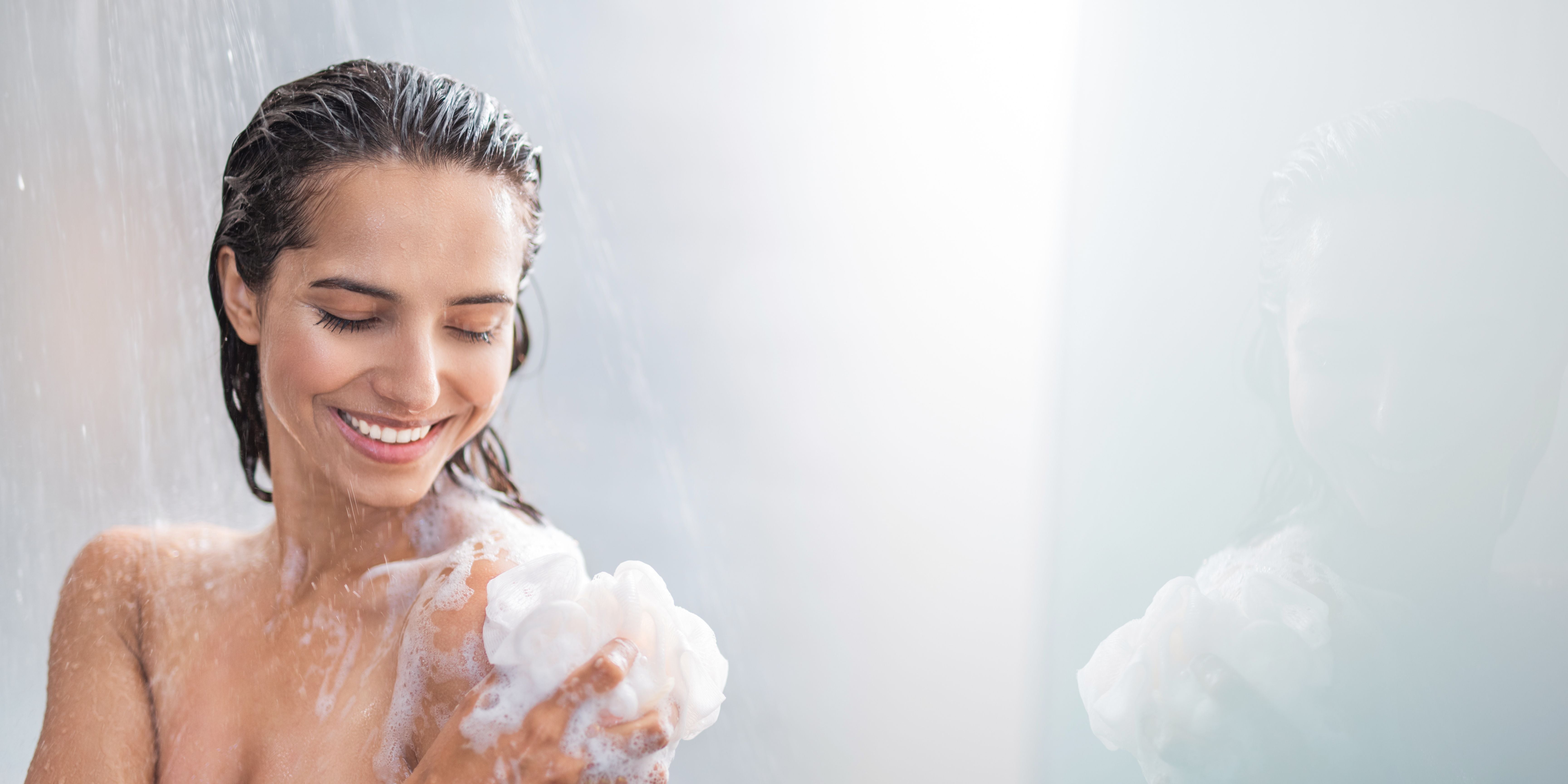 Woman in shower washing with soap suds 