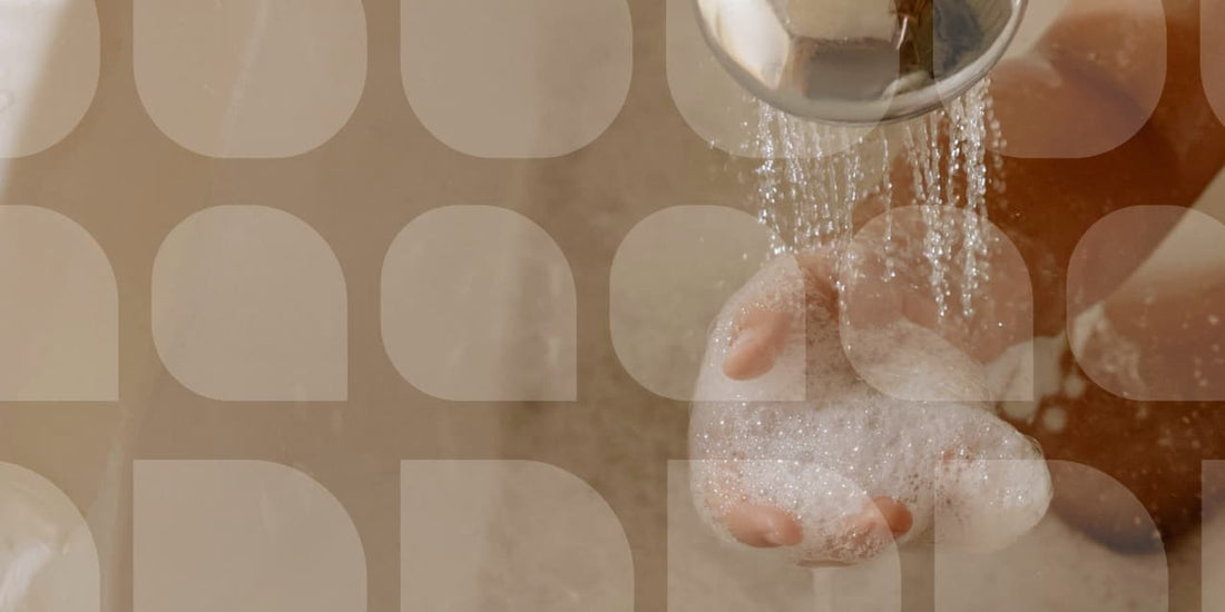 close up of soap bubbles in a hand under a shower. 