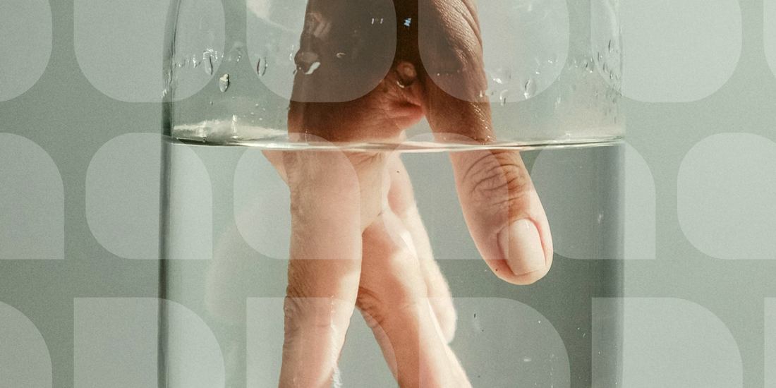 hand submerged in a glass of water