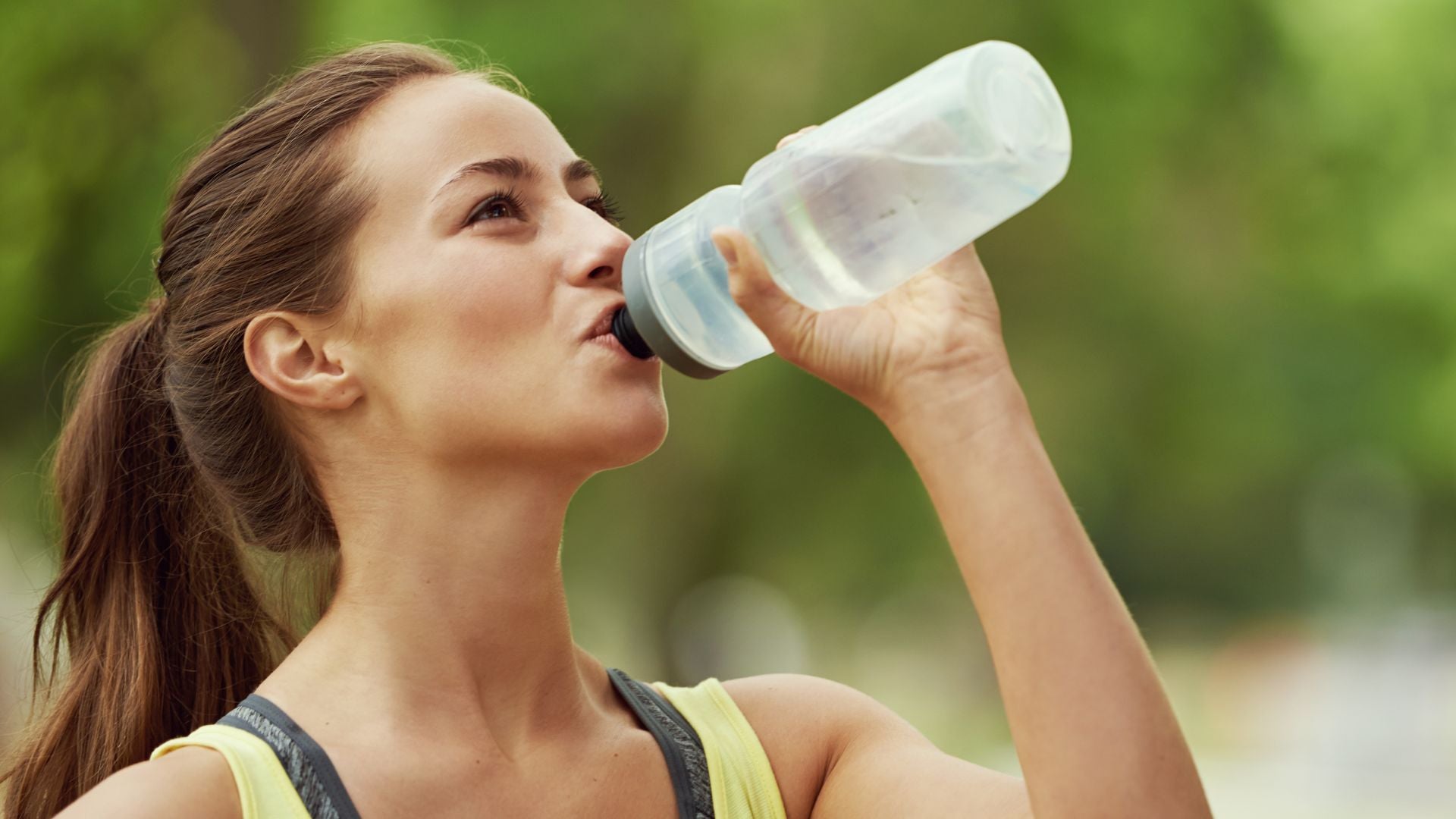 A girl is exercising and drinking water from a bottle