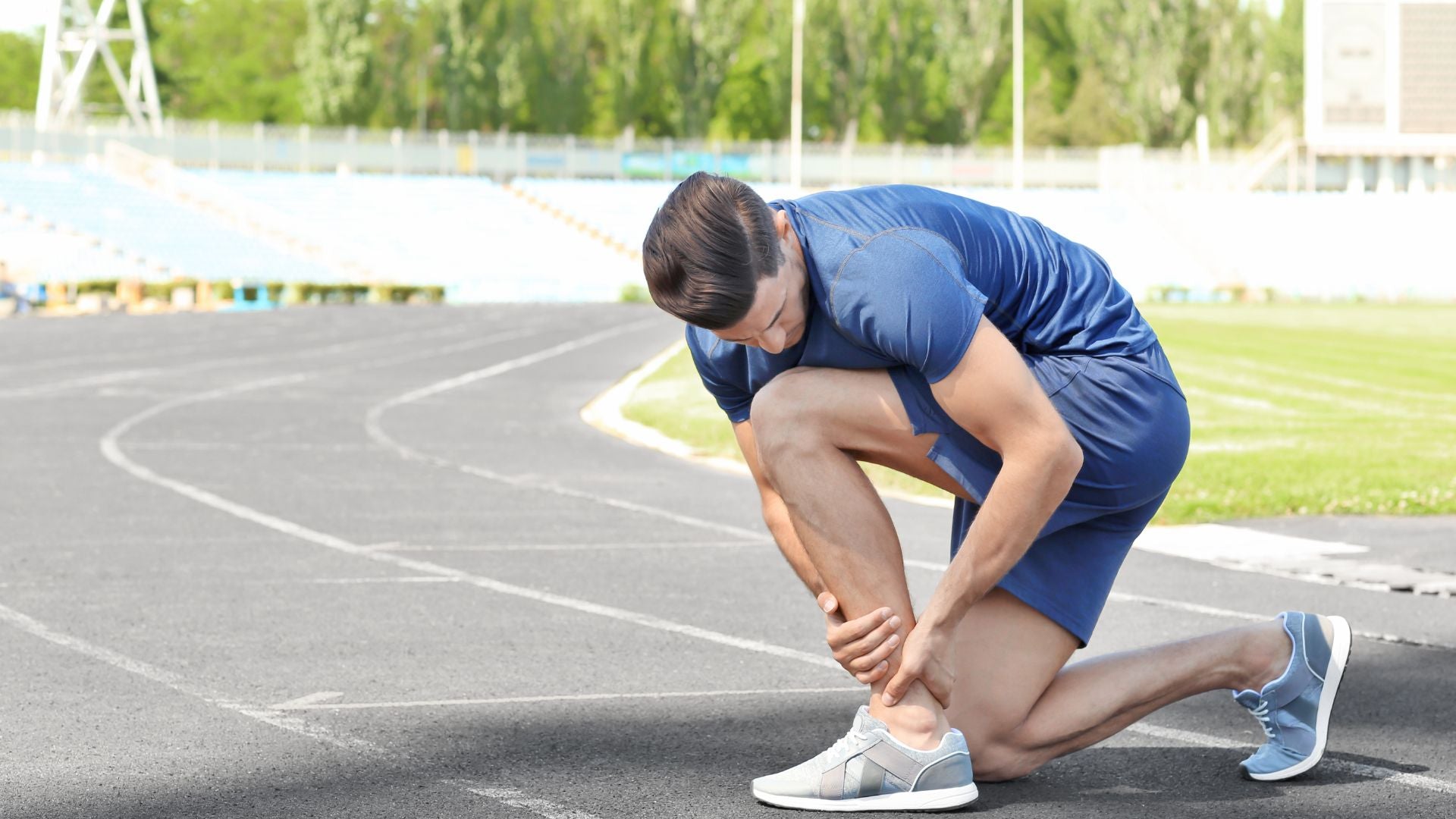 A male athlete kneeling on a running track