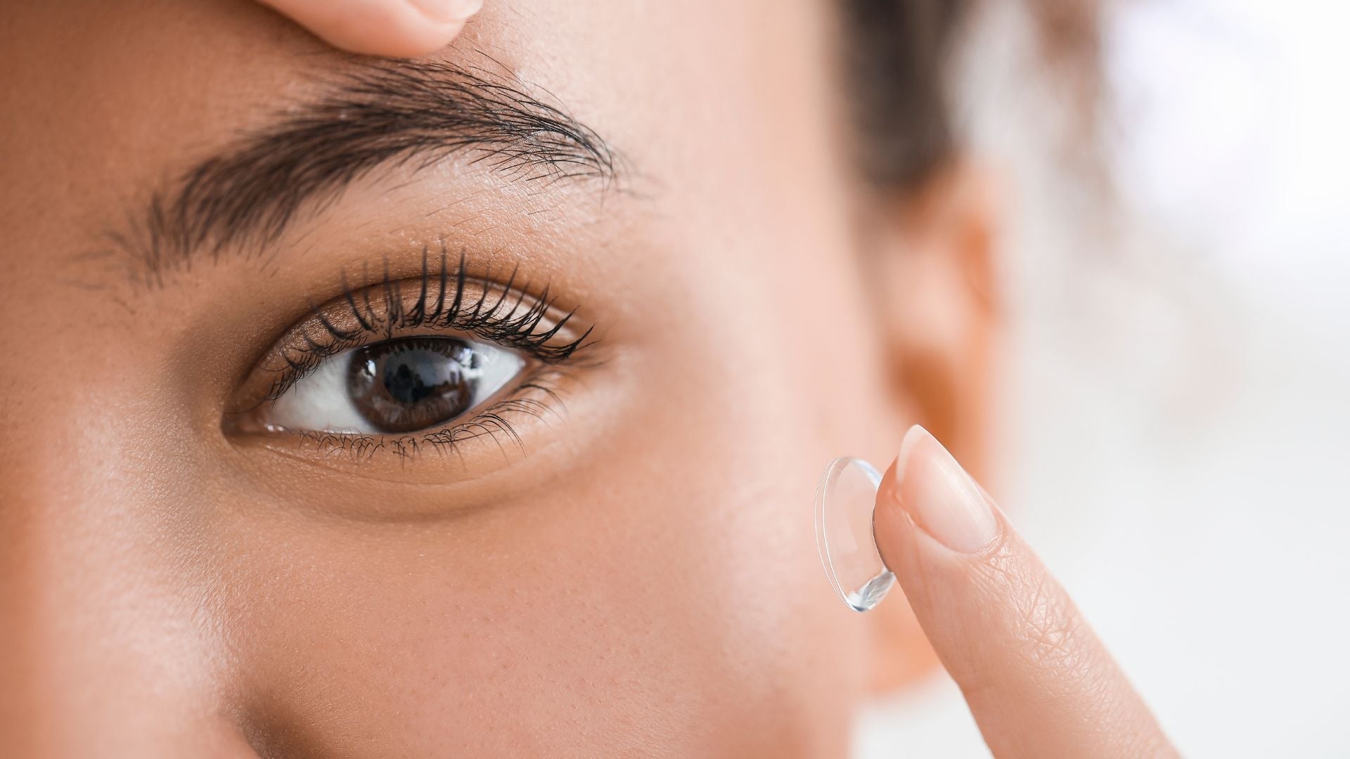 A woman putting in her contact lenses.