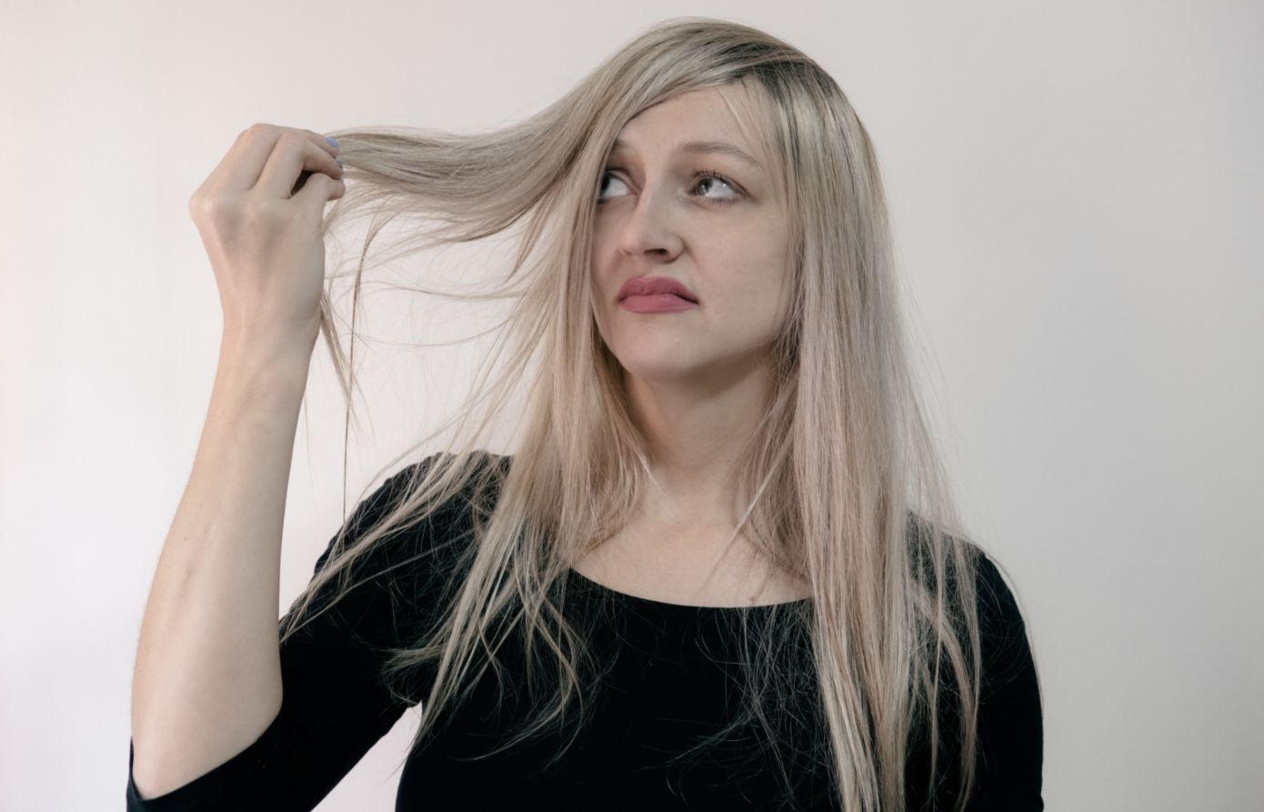 A woman looking disgusted by her hair