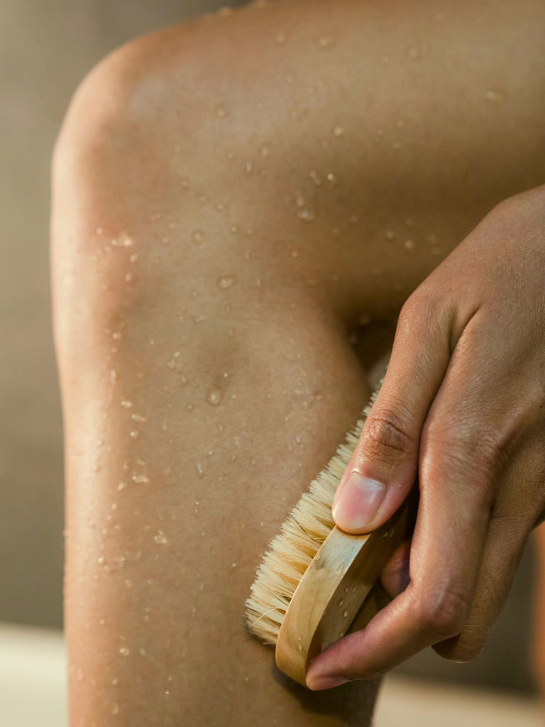 Person using a dry brush on their skin