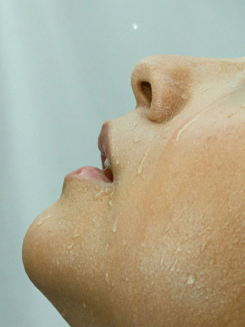 Close-up of a person's face with a neutral expression on a light gray background