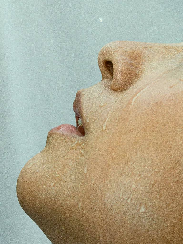 Close-up of a person's face with a neutral expression on a light gray background