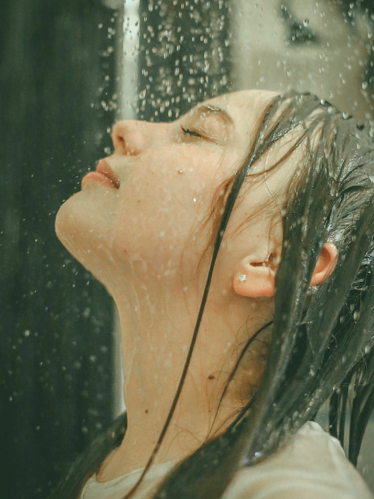 Person with wet hair under a shower