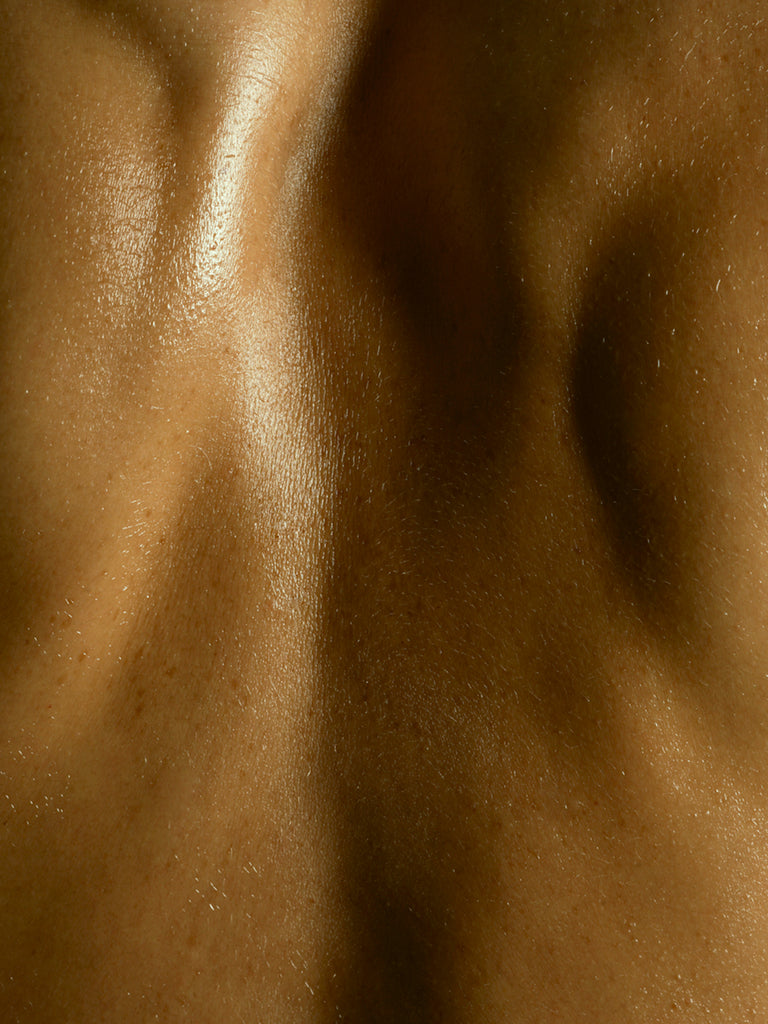 Close-up of a person's back with visible glowy skin texture.