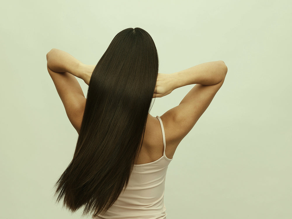 Woman with long, straight hair against a light green background