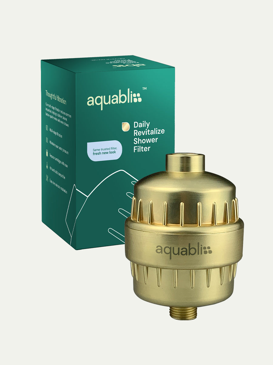 Gold shower filter with Aquabliss branding and green packaging on a white background