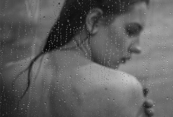 female taking shower using high volume showerhead