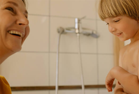 parent and kid happily taking shower