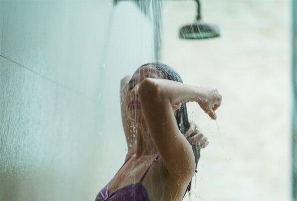 lady showering with hard water shower filter