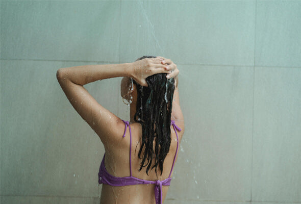 young lady taking shower while using shower filter for acne