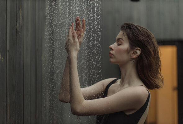young lady taking shower using flexible showerhead